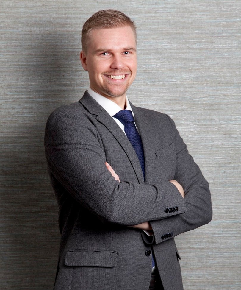 Founder of the enterprise - blond man in white shirt, blue tie, and grey jacket, smiling